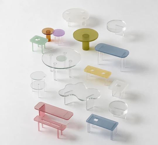 Collection of small coloured acrylic tables in clear, amber, blue, green and pink